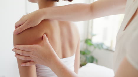 Back-and-shoulder-of-woman-being-massaged-by-hands