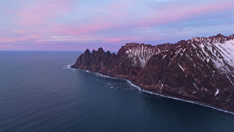 majestic mountain peaks of tungeneset, senja, meeting the arctic ocean at sunset
