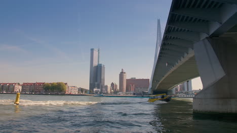 motorboat sailing under a bridge