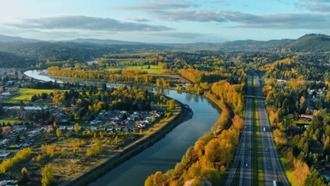 Scenic view combining the stunning nature of Oregon State and rural lifestyle. Picturesque village at the bank of the narrow river. Aerial view.