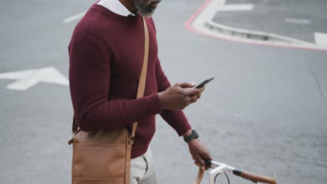 Afroamerikanischer-Mann,-Der-Sein-Telefon-Auf-Der-Straße-Benutzt