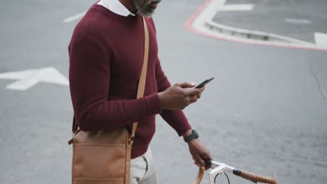 hombre afroamericano usando su teléfono en la calle