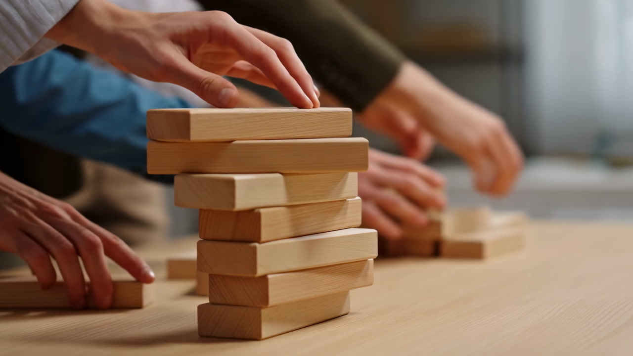 Hands Stacking Wooden Blocks On Table Closeup Showing Multiple Colleagues Hands Participating In Teambuilding