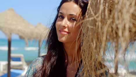 pretty lady leaning her head on beach umbrella