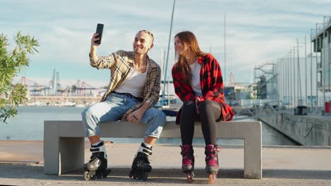 hombre alegre tomando una selfie en el teléfono inteligente con su novia en el terraplén