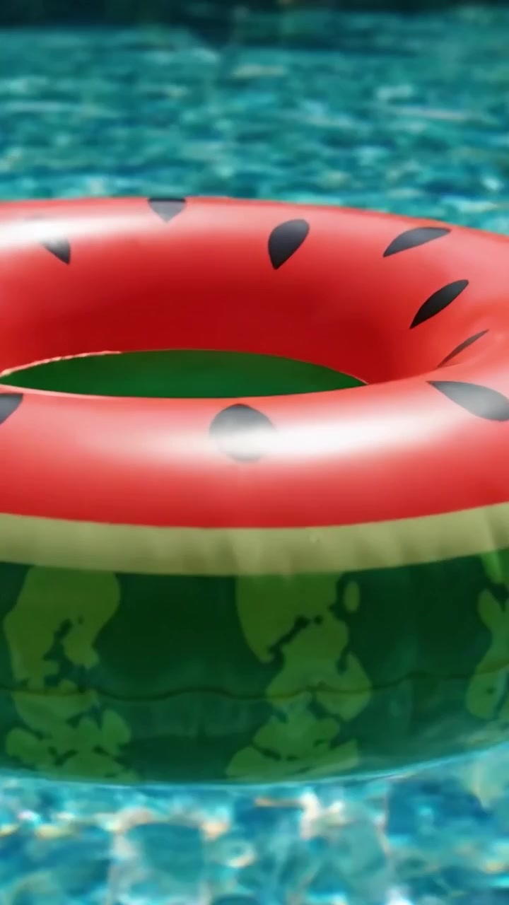 A Vibrant Inflatable Watermelon Pool Float Captured in a Shimmering Swimming Pool Setting for Summer Fun and Relaxation
