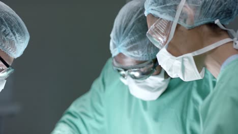 diverse surgeons with face masks during surgery in operating room in slow motion