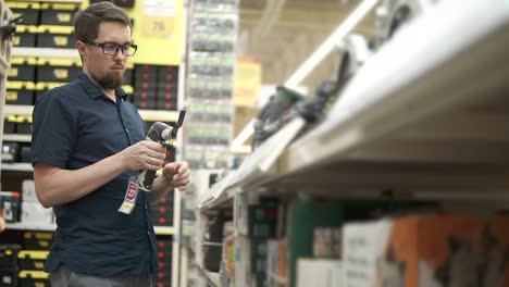 man shopping for power tools in a hardware store