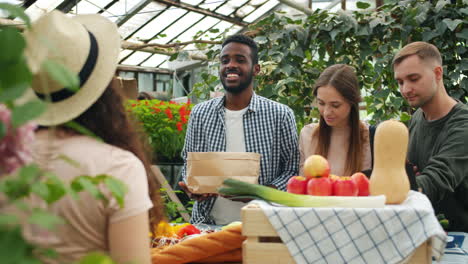 people shopping at a greenhouse farmers market