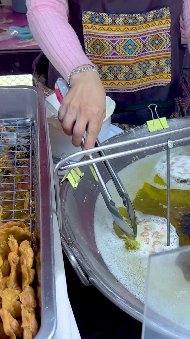 vendedor fritando cacahuetes en el puesto flotante del mercado