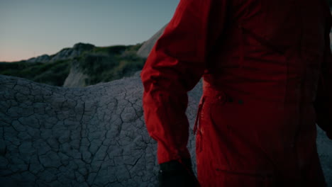 astronaut sits tired on a dry rock at night before sleeping sad