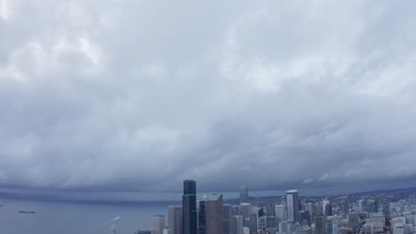 aerial shot tilting down from a sky of clouds to reveal seattle's downtown corridor