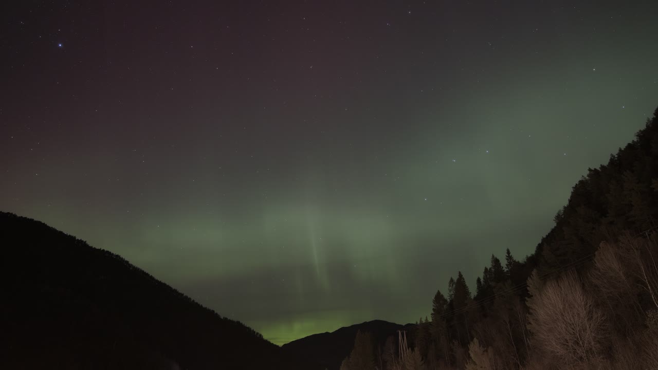 la luz verde de la aurora boreal llena el cielo nocturno sobre las montañas de noruega, timelapse