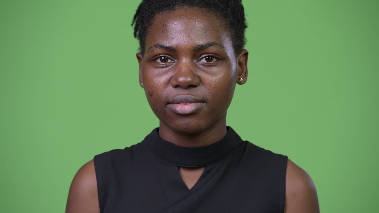 Young beautiful African businesswoman looking shocked