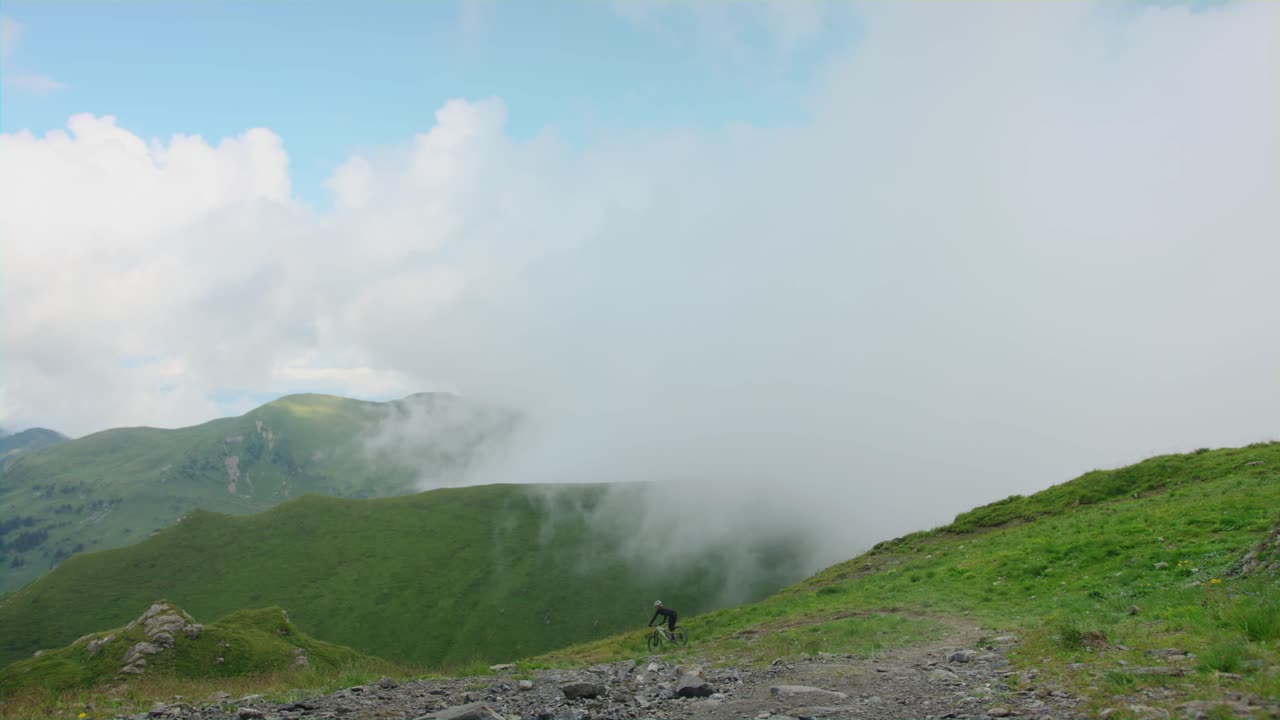 산악 자전거 타는 사람이 높은 고산 트레일을 질주합니다.