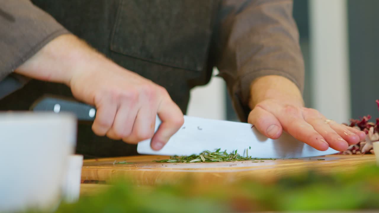 A chef chopping vegetables with a sharp knife, static close up