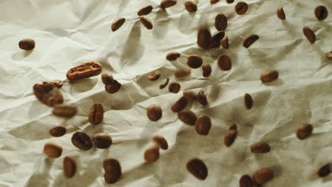 roasted coffee beans falling on wooden table surface in slow motion.