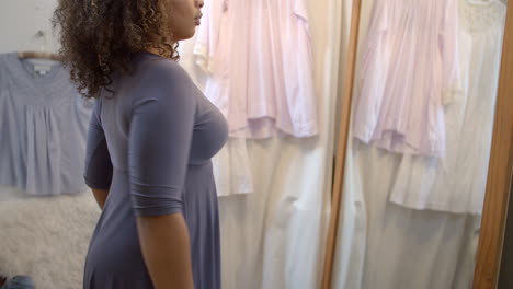 woman trying on a dress in a boutique changing room