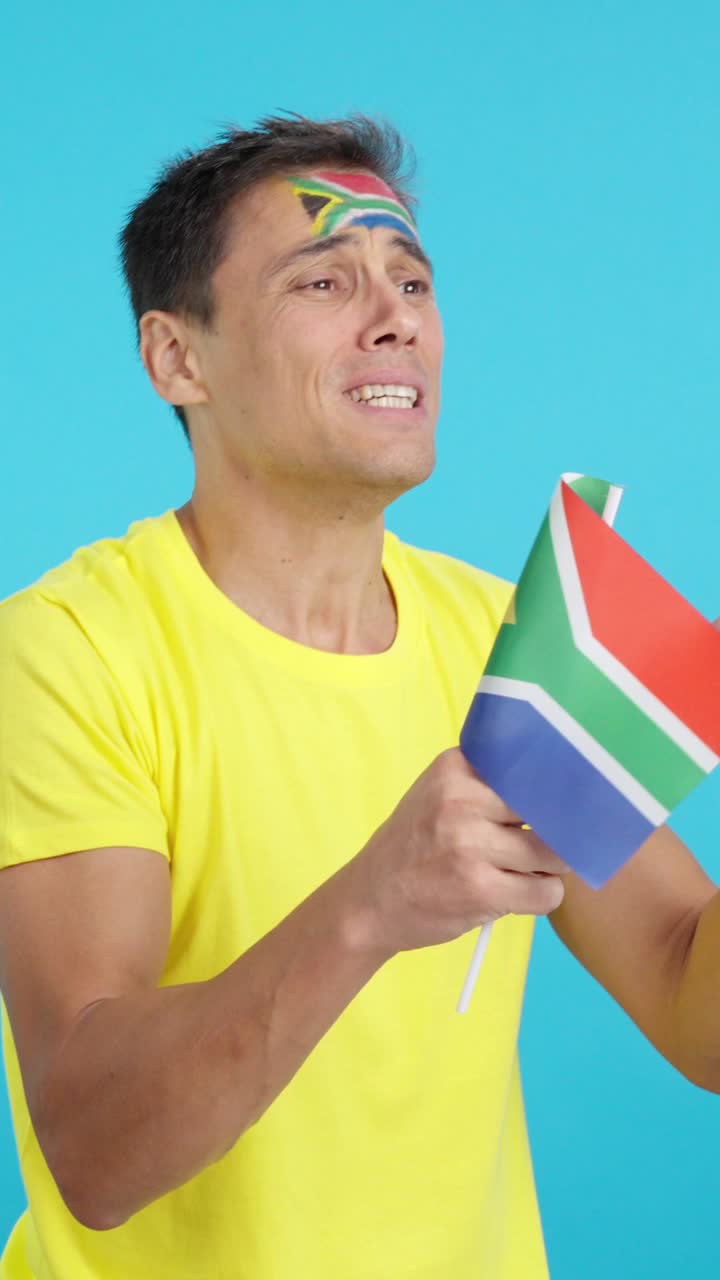 Nervous man cheering for South Africa during a match looking away