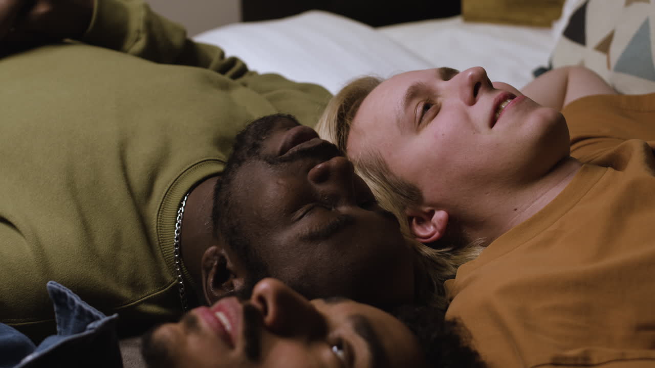 группа мужчин, лежащих на кровати.