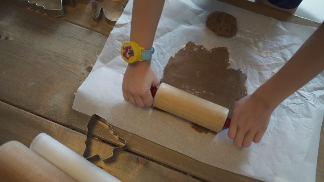 ребенок печет пряничное печенье на рождество в кругу семьи