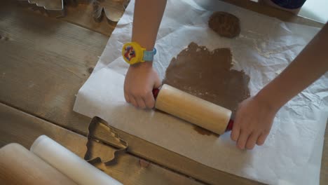 a child is baking gingerbread cookies at christmas with family