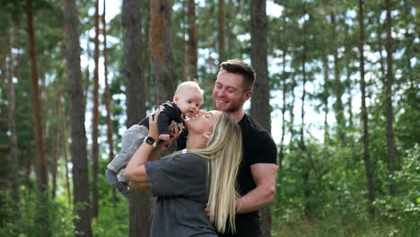 mom and dad with their newborn son spending time in the forest. happy family on vacation.