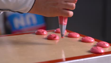 el chef de pastelería francés forma macarrones rojos