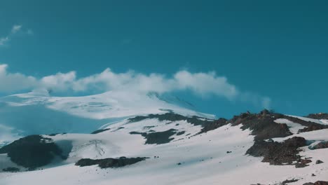 clouds flyes over snowy mountain crest