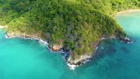 approaching drone shot descending over the coastal area of tayrona national park, in colombia, located in south america