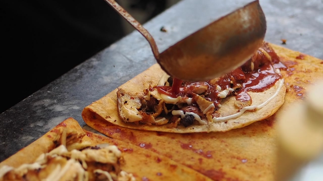 Adding Chili Sauce to a Chicken Flatbread Wrap