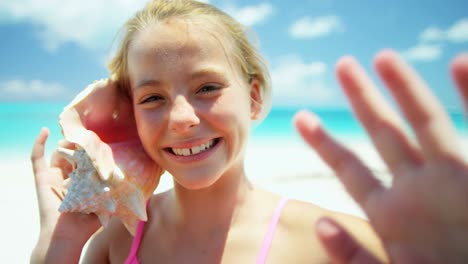 retrato de una niña en la playa sosteniendo una concha de concha