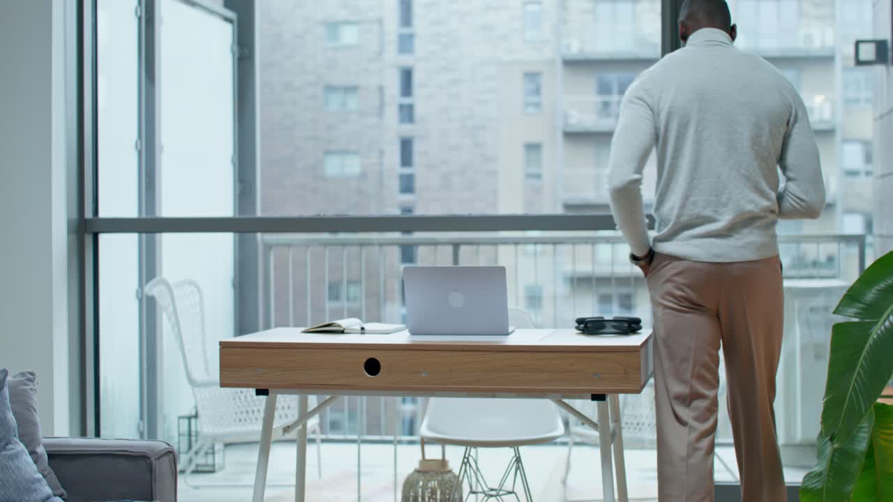 hombre trabajando desde su oficina en casa con vista a la ciudad