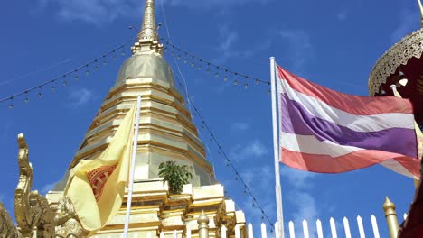 flag flutters by a golden buddhist stupa