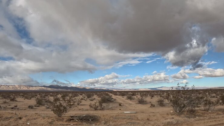 Mojave-ørkenlandskabet suser forbi, mens skyer krydser himlen i en kørende hyper-lapse fra en bilpassagers synspunkt