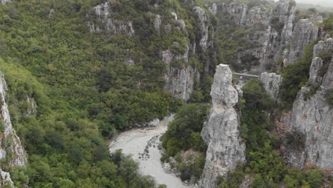 Drohnenvideo,-Das-Der-Schlucht-Zwischen-Steilen-Klippen-Und-Felsen-Folgt-Und-Zwei-Bogenbrücken-Enthüllt,-Kokori-Brücke,-Zagori,-Griechenland,-Nach-Unten-Schwenkend