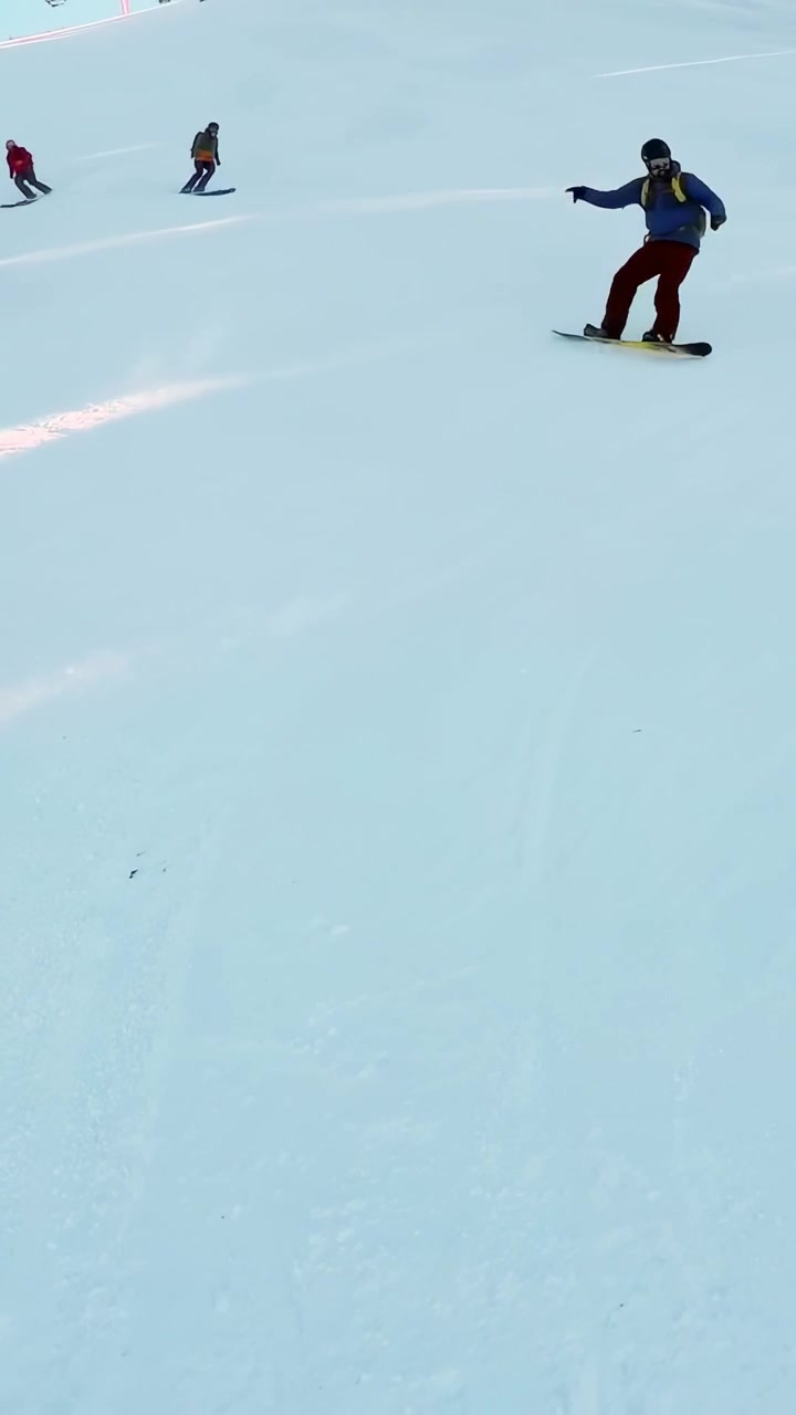 Video verticale: sciatori che iniziano la discesa, scivolando lungo la pista del resort con gli sci per sport, con spazio per il testo