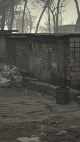 a brick wall with a trash can in front of it in the fog