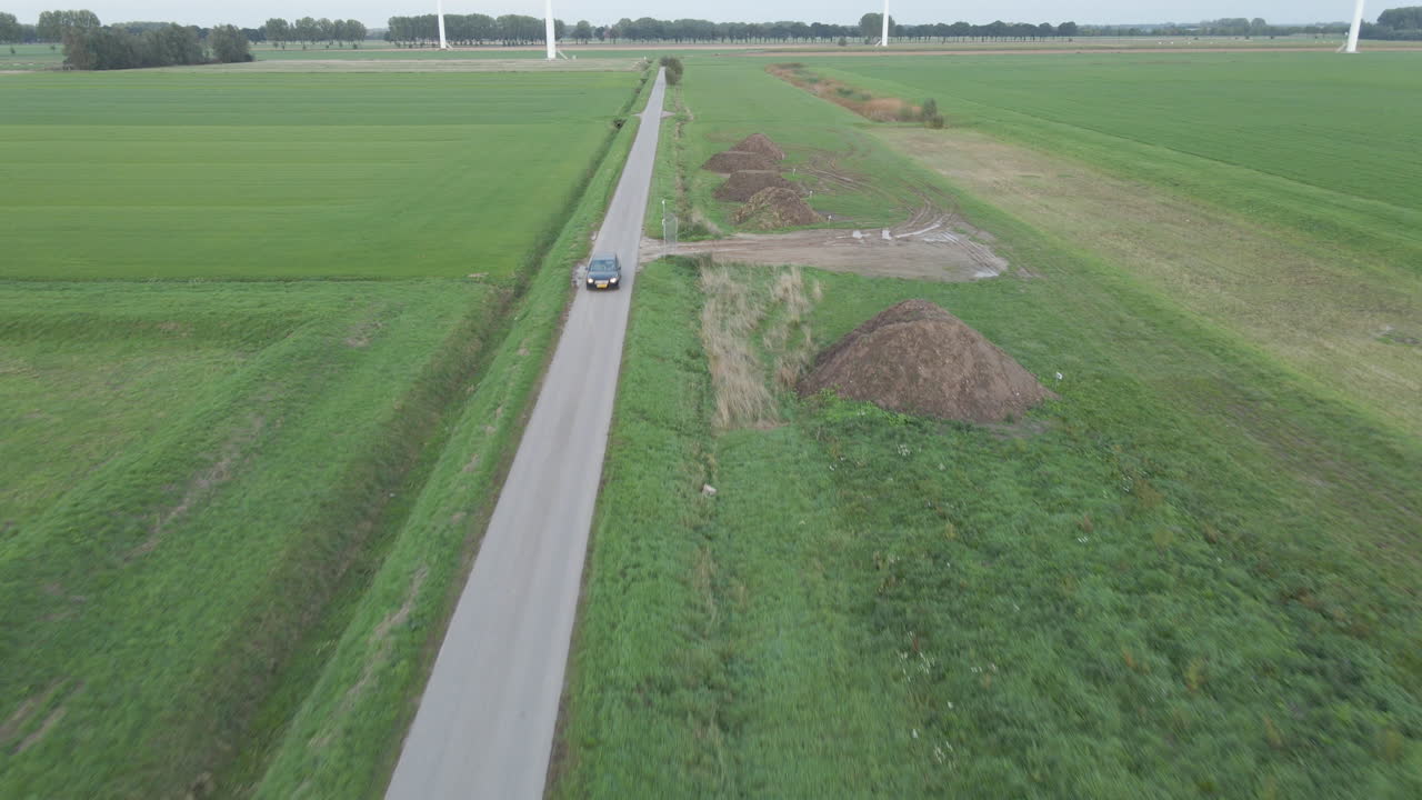 작은 시골 길을 운전하는 검은 차의 공중