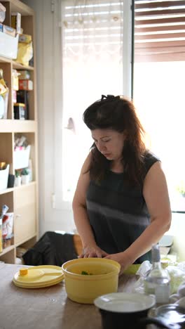 mujer preparando una ensalada en su cocina