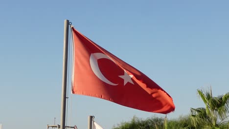 handgehaltene statische aufnahme der flagge der türkei im wind in slowmotion an einem sonnigen tag