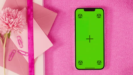 pink desktop with smartphone and envelopes