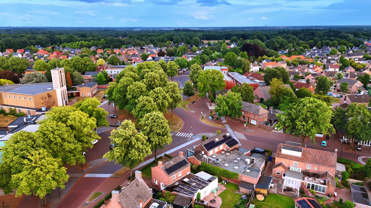 Picturesque panorama of a lovely little town with lush greenery. Aerial perspective on the roads near the church