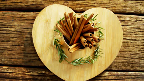 Cinnamon-sticks-and-rosemary-arranged-on-wooden-board-4k