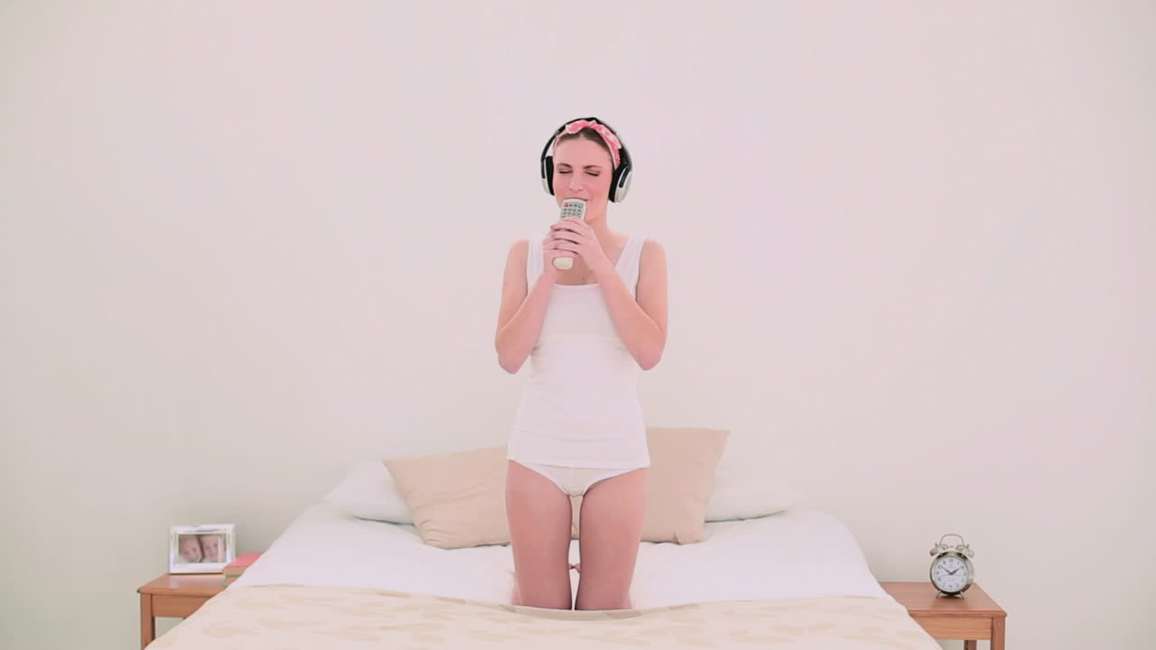 joven modelo escuchando música y cantando en su cepillo de pelo