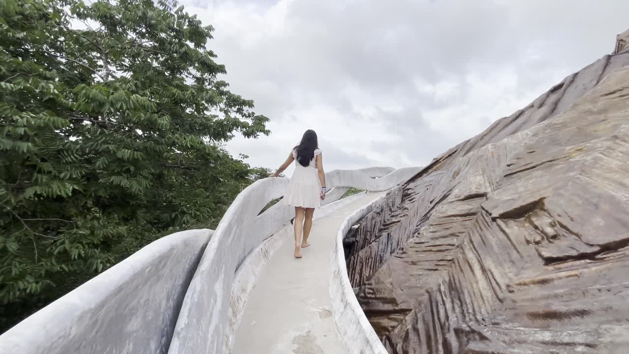 Woman walking starring at art in Azulik museum, in Tulum, Mexico