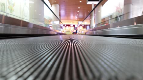 moving walkway at the airport, also known as an autowalk, moving sidewalk, moving pavement, people-mover, travolator, or travelator, is a slow-moving conveyor mechanism that transports people.