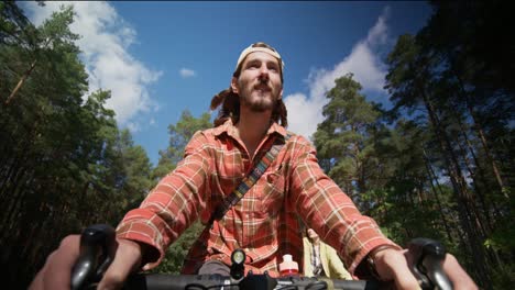 una pareja en bicicleta en el bosque.
