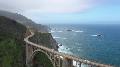 Vehículos-Conduciendo-En-El-Puente-Bixby-Creek-Con-Vistas-Al-Paisaje-Marino-En-Big-Sur,-Monterey,-California