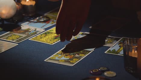 close up of woman giving tarot card reading on candlelit table